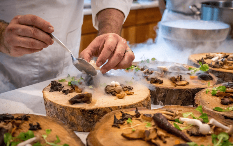 chef sorting out fall inspired veggies on wooden plates