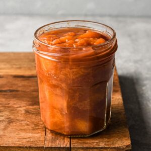 Finished peach compote in a glass jar.