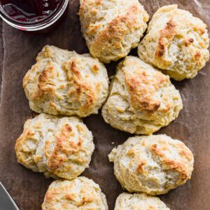 Drop Biscuits on parchment paper with jam in the corner.