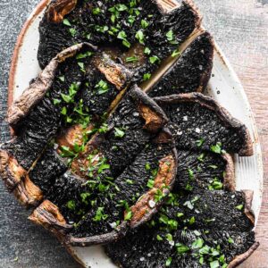 Close up image of sliced mushrooms on a serving plate.