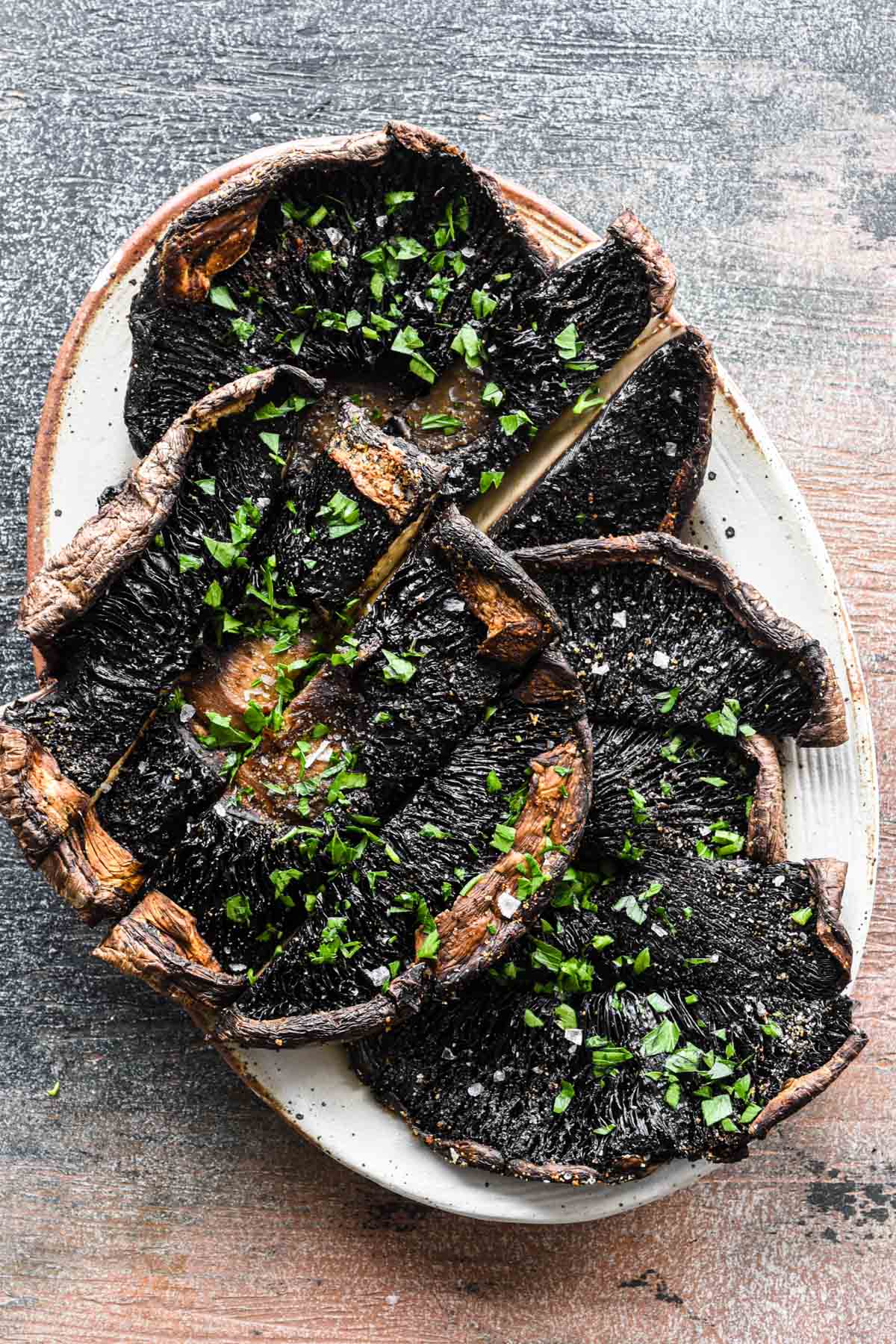 Close up image of sliced mushrooms on a serving plate.