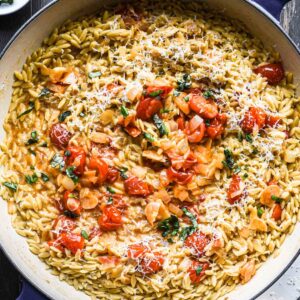 Overhead close up image of finished orzo with tomatoes.