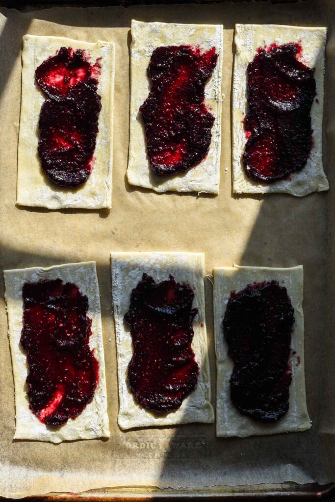 Jam on squares of puff.