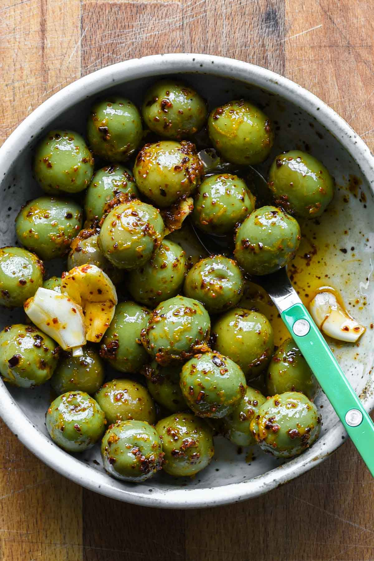 Close up photo of marinated olives in a serving bowl.