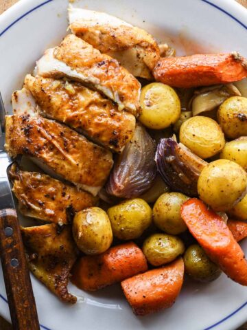 Dutch oven roasted chicken served on a plate.