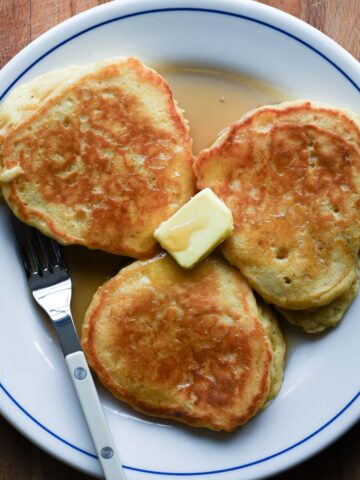 Close up of pancakes with a pat of butter and pure maple syrup.