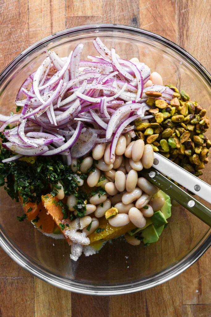 Salad ingredients added to a large bowl.