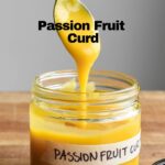 Passion fruit curd in a labeled jar with a spoon dipping.